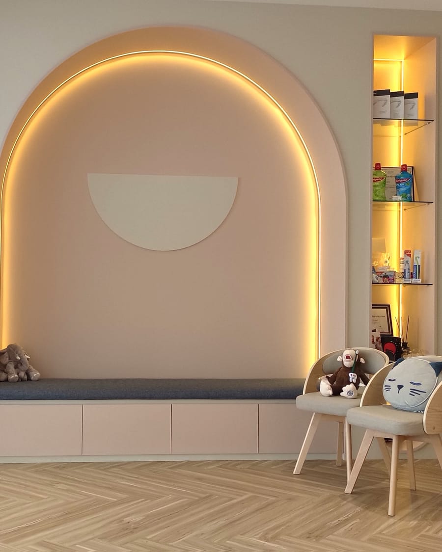 Kid-friendly waiting nook with a cushioned bench and toys at Alpha Dental, Sutera Utama, Skudai